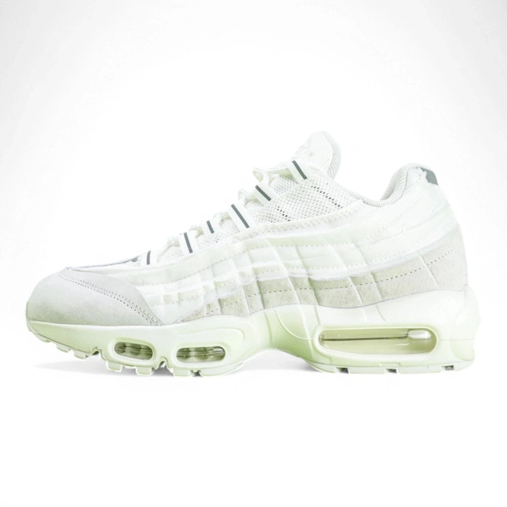 Air Max 95 x Comme des Garçons White - Heel Rear Three-Quarter View on Green Background Showing Silver Hard Plastic AM95 Heel Stabiliser with AIR Text Tonal White Suede Upper and White Translucent Air Unit