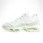 Air Max 95 x Comme des Garçons White - Heel Rear Three-Quarter View on Green Background Showing Silver Hard Plastic AM95 Heel Stabiliser with AIR Text Tonal White Suede Upper and White Translucent Air Unit