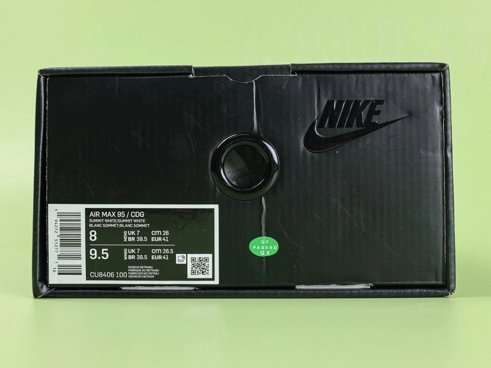 Air Max 95 x Comme des Garçons White - Toe Box Close Up on Green Background Showing Matte White Suede Mudguard White Mesh Quarter Panel and Reflective Grey Lace Loops