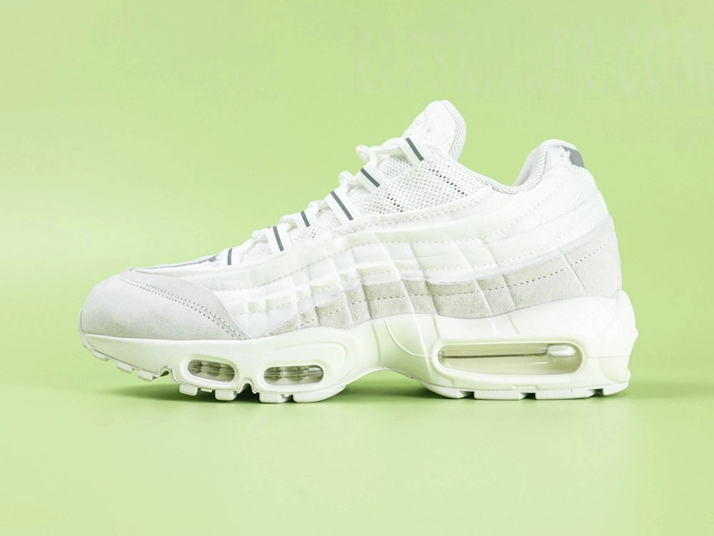 Air Max 95 x Comme des Garçons White - Outsole View on Green Background Showing Full White AM95 Square Block Waffle Tread with Central Translucent Window Revealing Black and White Striped Insole Graphic