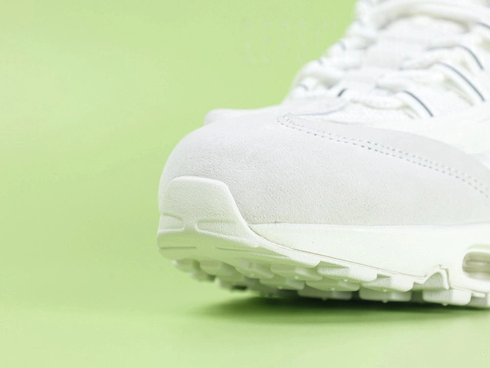 Air Max 95 x Comme des Garçons White - Heel Angled View on Green Background Showing Silver AM95 Heel Stabiliser AIR Text White Flat Laces and White Translucent Heel Air Unit