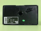 Air Max 95 x Comme des Garçons Black - Toe Box Close Up on Green Background Showing Matte Black Suede Mudguard Black Mesh Quarter Panel and Reflective Grey Lace Loops