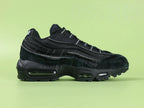 Air Max 95 x Comme des Garçons Black - Toe Box Top Down View on Green Background Showing Black Suede Mudguard Black Mesh Upper and Reflective Grey Lace Dubrae Details
