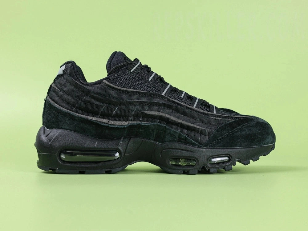 Air Max 95 x Comme des Garçons Black - Toe Box Top Down View on Green Background Showing Black Suede Mudguard Black Mesh Upper and Reflective Grey Lace Dubrae Details