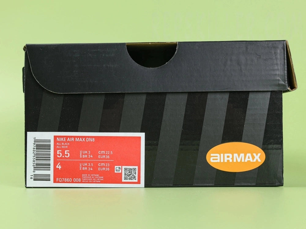 Air Max Dn8 All Black - Heel Close Up on Green Background Showing Silver Circular AIR Badge with Red Dn Accent Black Mesh Collar and Translucent Black Dn8 Air Pods