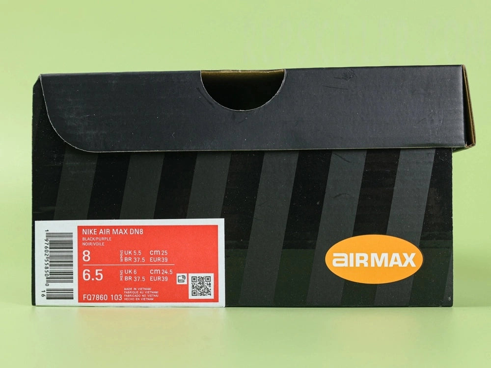 Air Max Dn8 Black Purple - Heel Close Up on Green Background Showing Gold Rainbow Iridescent Circular Air Badge with Orange Dn Accent Black Mesh Collar and Translucent Grey Purple Dn8 Air Pods