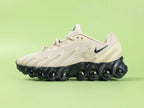 Air Max Dn8 Desert Khaki Black - Outsole View on Green Background Showing Full Black Rubber Outsole with Large Blue Air Cushion Windows at Forefoot and Heel Red Circular Traction Studs and Gold Circular Dn Badge at Midfoot