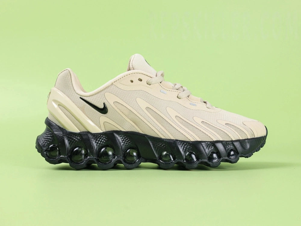 Air Max Dn8 Desert Khaki Black - Toe Box Top Down View on Green Background Showing Desert Khaki Bone Engineered Mesh Upper Smooth Synthetic Leather Overlays and Black Mini Swoosh at Midfoot