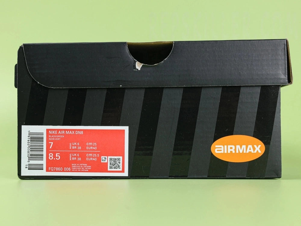 Air Max Dn8 Black Volt - Outsole View on Green Background Showing Full Black Rubber Outsole with Red Circular Traction Studs Grey Translucent Air Window and Gold Circular Dn Badge at Midfoot