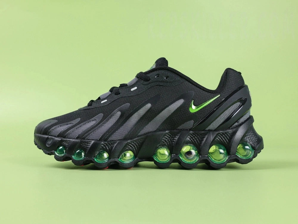 Air Max Dn8 Black Volt - Toe Box Close Up on Green Background Showing Black Engineered Mesh Upper Black TPU Overlays and Volt Green Dn8 Air Pod at Forefoot