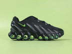 Air Max Dn8 Black Volt - Tongue Close Up on Green Background Showing Grey Oval AIRMAX Badge with Volt Green Lettering and Orange Circular Dn8 Insole Badge
