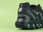 Air Max Dn8 Black Volt - Swoosh Close Up on Green Background Showing Metallic Volt Green Chrome Mirror Finish Swoosh on Black Engineered Mesh Midfoot Panel