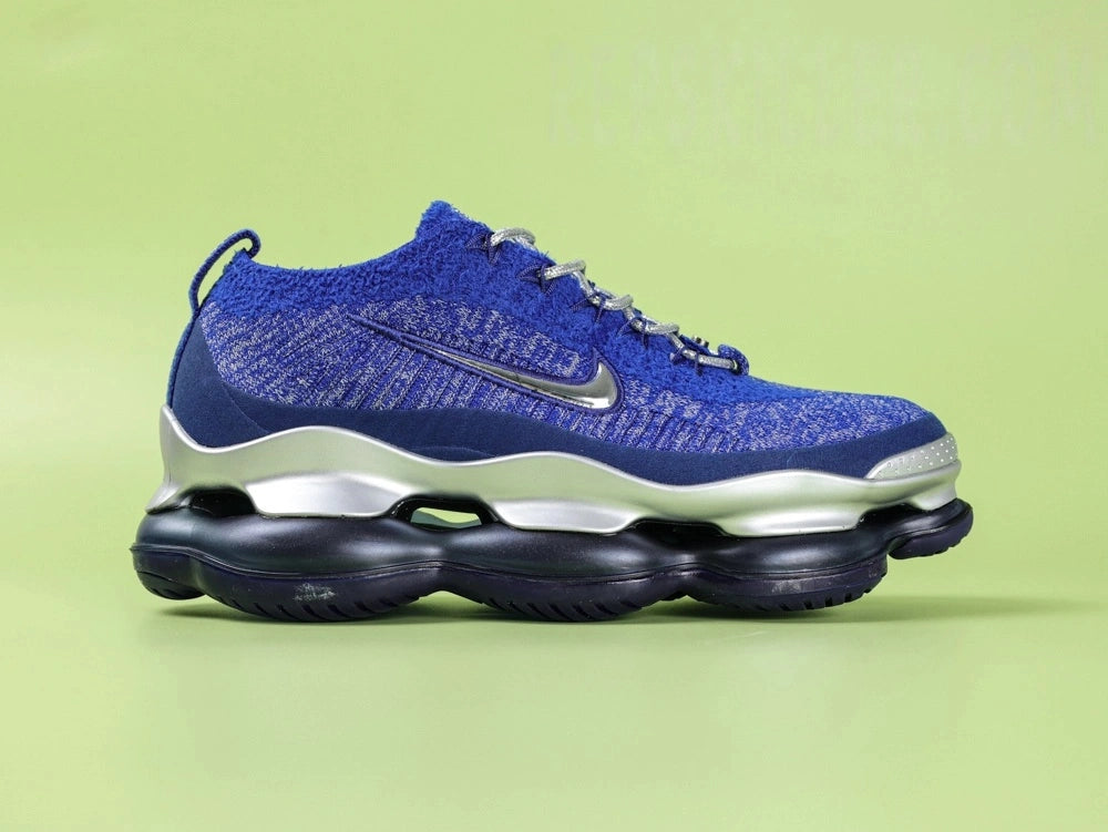 Air Max Scorpion FK Blue Fury - Toe Box Top Down View on Green Background Showing Royal Blue Flyknit Upper Silver Embroidered Mini Swoosh Silver Metallic Rope Laces and Silver Circular Lace Dubrae