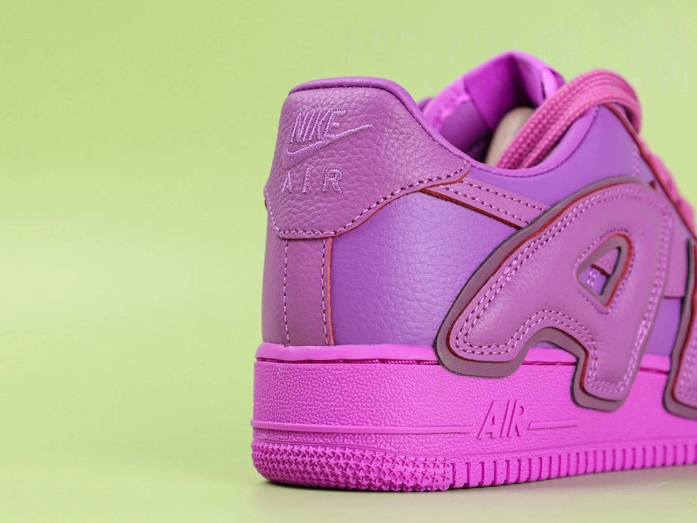 Nike x CPFM Air Force 1 Low Premium Fuchsia Dream - pair three quarter view green background