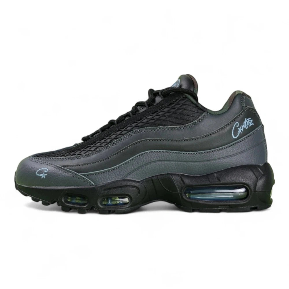 Air Max 95 SP Corteiz Aegean Storm - Single Lateral Full Side View with Pikachu on Sofa Showing Full Black Upper Diamond Quilted Mesh Black Charcoal Gradient Spine Iridescent Blue Swoosh White Corteiz Script and Steel Blue Air Units