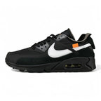 Off-White x Air Max 90 Black - Three-Quarter Lateral View of Both Shoes on Olive Background Showing Triple Black Upper White Raw-Edge Swoosh Orange Zip-Tie and Light Blue Heel Zip-Tie with White Laces Bag