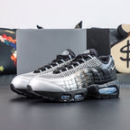Palace x Air Max 95 Big Bubble Metallic Silver 2026 - Three-Quarter Top View of Both Shoes on Dark Background Showing Metallic Silver Upper Black Spine Overlays Black Rope Laces with White Stripes and Palace Oval Badge on Tongue
