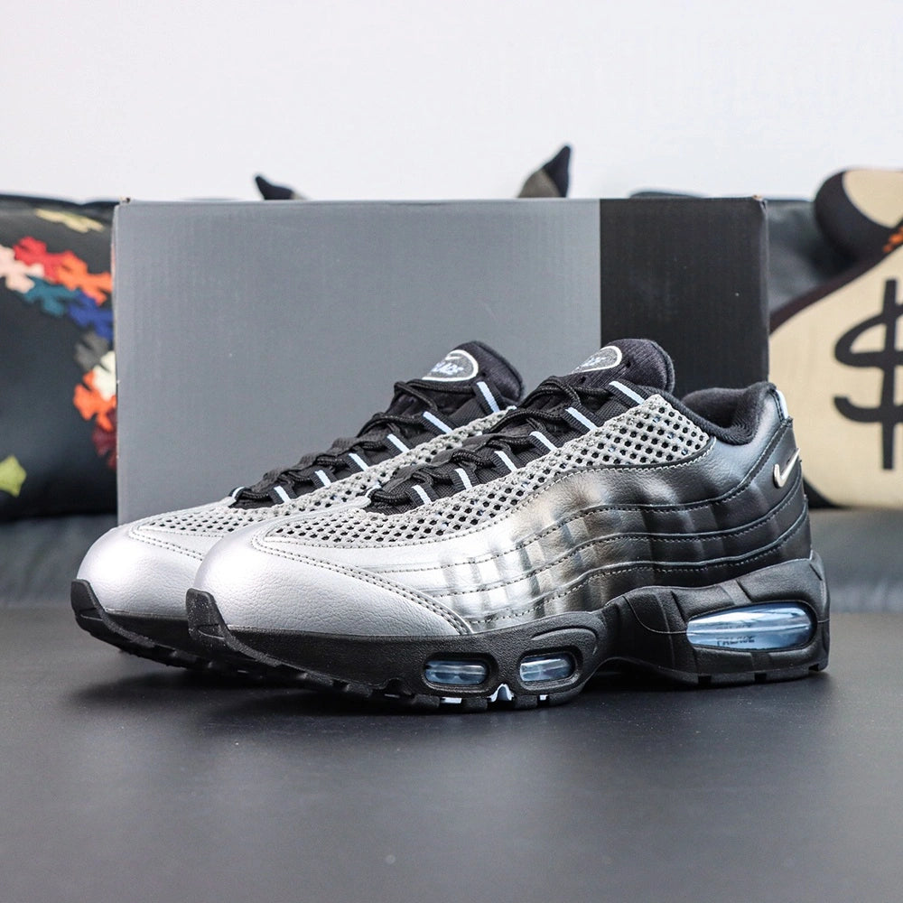 Palace x Air Max 95 Big Bubble Metallic Silver 2026 - Three-Quarter Top View of Both Shoes on Dark Background Showing Metallic Silver Upper Black Spine Overlays Black Rope Laces with White Stripes and Palace Oval Badge on Tongue