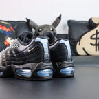 Palace x Air Max 95 Big Bubble Metallic Silver 2026 - Rear Heel View of Both Shoes on Dark Background Showing White-to-Black Halftone Dot Gradient on Heel Tab with White PALACE Text at Top and Ice Blue Big Bubble Air Unit at Heel