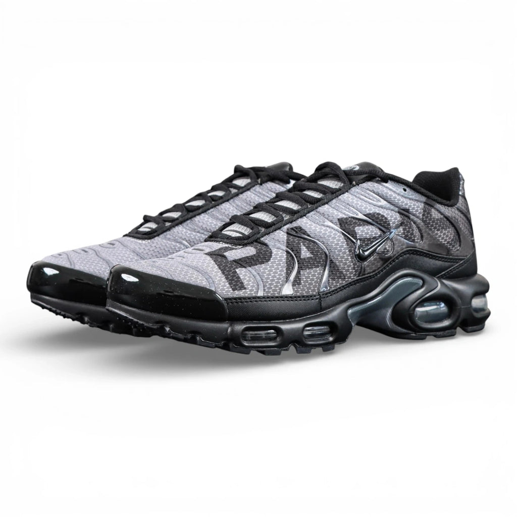 Paris Saint-Germain x Air Max Plus Black Particle Grey - Full Lateral Profile View on Dark Background Showing Black Patent Leather TN Upper Particle Grey Hex Mesh with Black PSG Lettering Black Mini Swoosh and Yellow Tn AIR Heel Badge