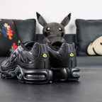 Paris Saint-Germain x Air Max Plus Black Particle Grey - Lateral Profile View with Red Shoebox on Dark Background Showing Black Patent Leather TN Upper Particle Grey Hex Mesh PSG Lettering and Yellow Tn AIR Heel Badge