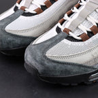 SB x Air Max 95 Cacao Wow 2026 - Three-Quarter Lateral View with Purple Shoebox on Dark Background Showing White Grey Gradient Suede AM95 Upper Brown Grosgrain Ribbon Lace Tabs and Cacao Wow Mini Swoosh
