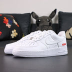 Supreme x Air Force 1 Low Box Logo White - pair overhead flat lay black background red Supreme badge