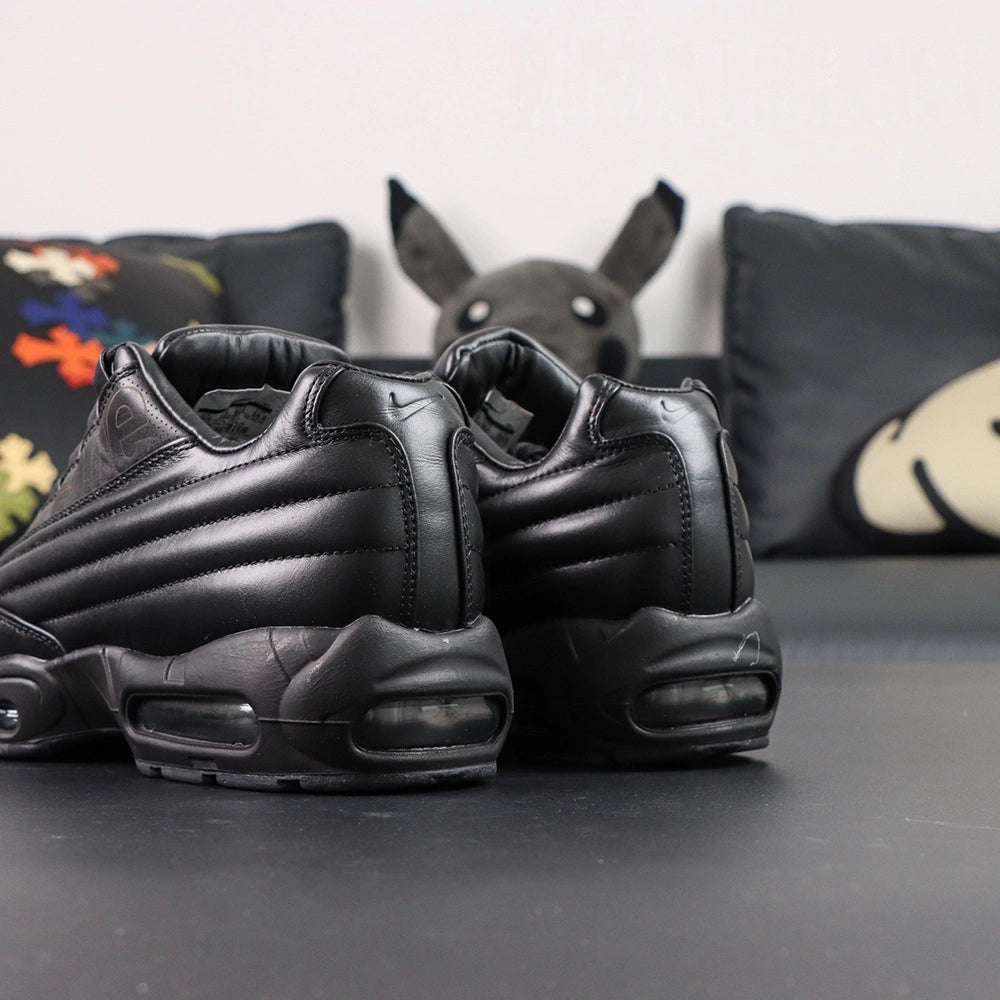 Supreme x Air Max 95 Lux Black - Full Lateral Profile View on White Background Showing Premium Black Leather AM95 Spine Overlay Construction Debossed Supreme Script on Quarter Panel and Dark-Tinted AM95 Air Units