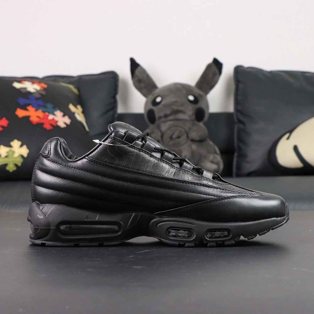 Supreme x Air Max 95 Lux Black - Tongue and Insole Top Down View on Dark Background Showing Debossed Supreme New York Script on Leather Tongue and Gold Supreme x NK SB Made in Italy Co-Branding on Black Insole