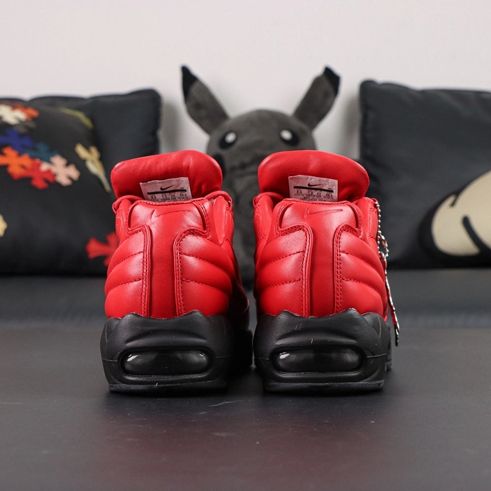 Supreme x Air Max 95 Lux Gym Red - Three-Quarter Lateral View of Both Shoes on Dark Background Showing Full Gym Red Leather Upper Tone-on-Tone Supreme Script Quilted Diamond-Stitch Heel Collar and Black AM95 Midsole