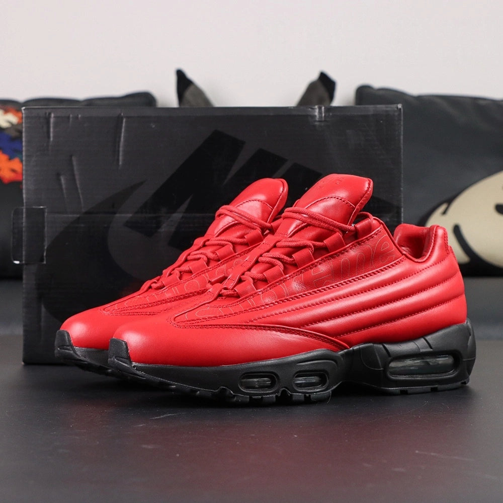 Supreme x Air Max 95 Lux Gym Red - Lateral Profile View on Dark Background with Pikachu Plush Showing Full Gym Red Leather AM95 Upper Tone-on-Tone Supreme Script and Full Black Midsole Outsole