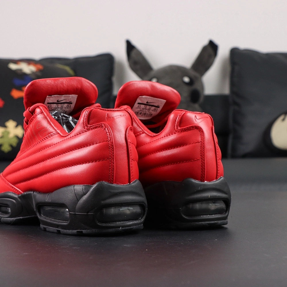 Supreme x Air Max 95 Lux Gym Red - Rear Heel View of Both Shoes with Pikachu Plush on Dark Background Showing Quilted Diamond-Stitch Red Leather Heel Collar Black Metal Ball-Chain Dubrae and Full Black AM95 Midsole