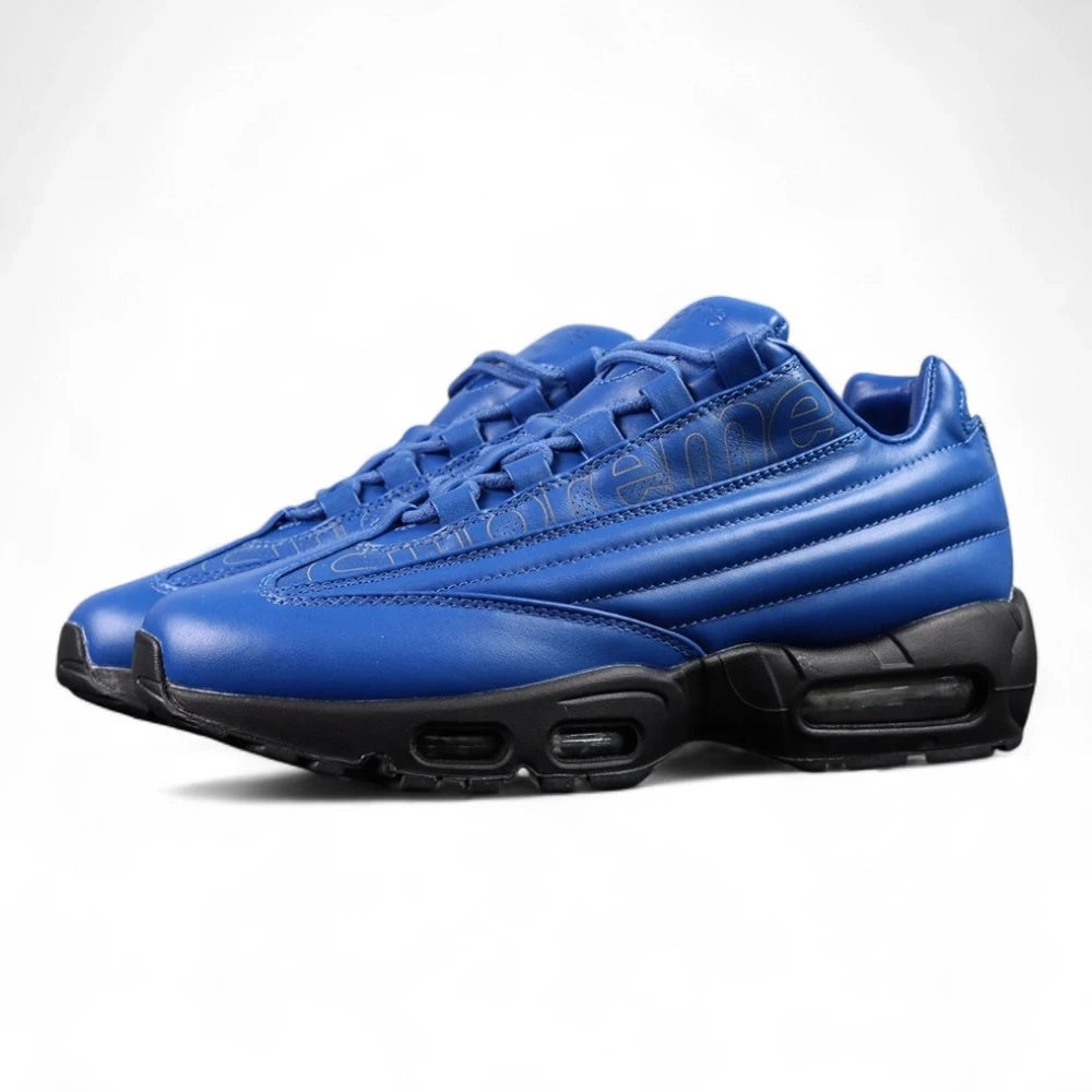 Supreme x Air Max 95 Lux Hyper Cobalt - Lateral Profile and Outsole View on Dark Background Showing Full Hyper Cobalt Blue Premium Leather AM95 Upper Silver Metal Key Charm on Heel Eyelet and Full Black AM95 Outsole with PSI Air Pressure Markings