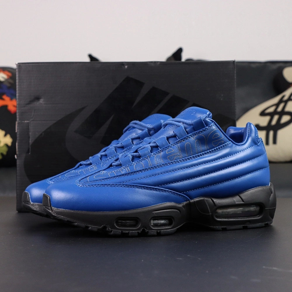 Supreme x Air Max 95 Lux Hyper Cobalt - Full Lateral Profile View on Dark Background with Pikachu Plush Showing Complete Hyper Cobalt Blue Premium Leather AM95 Lux Upper Tone-on-Tone Supreme Script and Full Black Midsole Outsole