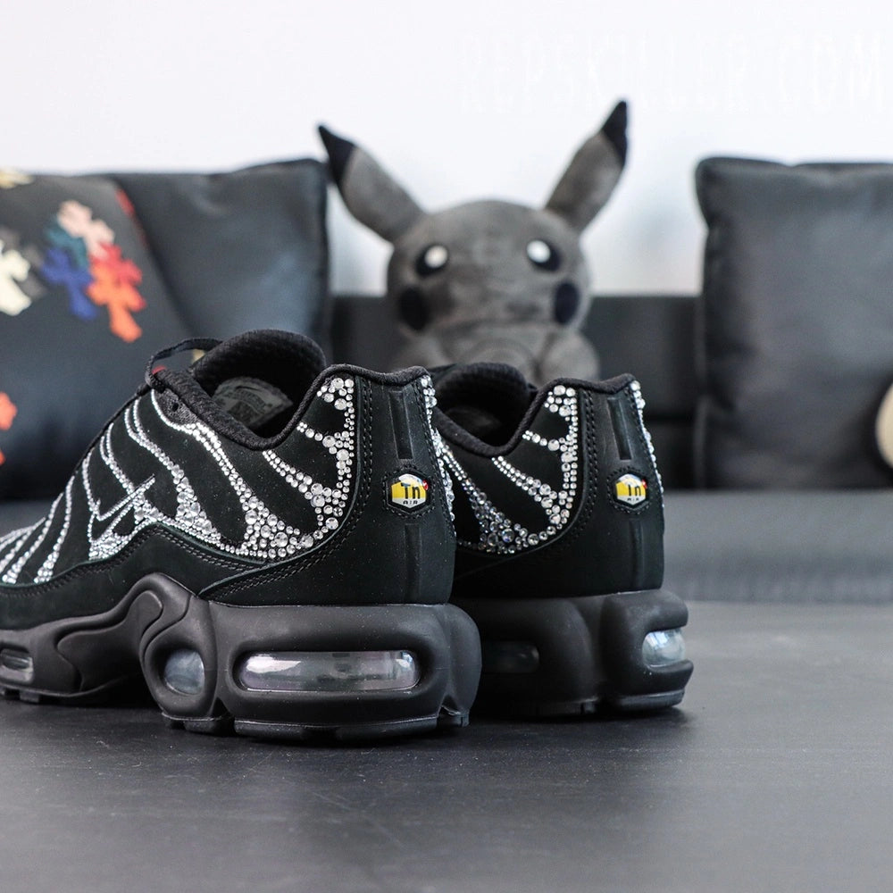 Swarovski x Air Max Plus Moonlight 2024 - Full Lateral Profile View with Pikachu Plush on Dark Background Showing Complete Triple Black TN Upper with Swarovski Crystal Rhinestone Wave-Form Lines and Crystal Swoosh on Lateral Midfoot