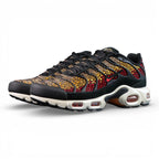 Swarovski x Air Max Plus Sunset - Lateral Profile and Outsole View on Dark Background Showing Black TN Upper with Swarovski Crimson to Gold Sunset Crystal Gradient and Tri-Colour Outsole with Black Rubber Red Triangular Traction Blocks and Orange Underlayer