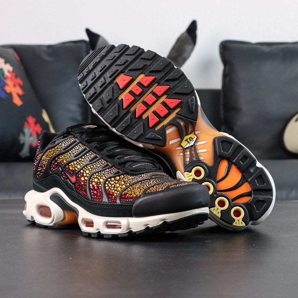 Swarovski x Air Max Plus Sunset - Rear Heel View of Both Shoes with Pikachu Plush on Dark Background Showing Deep Crimson Swarovski Crystal Coverage on Heel Counter Wave-Form Panels Yellow Tn AIR Badge and White Midsole with Amber Air Unit at Heel