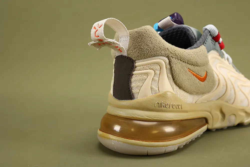 Air Max 270 React Cactus Jack Light Cream Starfish CT2864-200 - Heel Counter Close Up on Olive Background Showing Cream CACTUS JACK Pull Tab with Red Hand-Script Embroidery Red Cactus Logo at Top Deep Espresso Leather Heel Patch and Gum 270 Air Unit