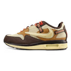 Air Max 1 Cactus Jack Baroque Brown Wheat Cream University Red - Full Lateral Profile View on Olive Background Showing Cream Woven-Texture Swoosh Baroque Brown Nubuck Overlays Cream Coarse Woven Mesh Wheat Quarter Panel Black Multicolour Woven Webbing Lace Loops University Red White-Speckle Rope Laces Cream Circular Lace Lock Baroque Brown Suede Mudguard and Cream Aged AM1 Midsole with Heel Air Window