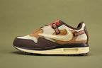 Air Max 1 Cactus Jack Baroque Brown Wheat Cream University Red - Toe Box Close Up on Olive Background Showing Baroque Brown Smooth Nubuck Toe Box Overlay with Tonal Edge Stitching Cream Coarse Square-Grid Woven Mesh Toe Box Body Baroque Brown Suede Mudguard and Cream Aged AM1 Midsole with Dark Navy Rubber Outsole and Lug Traction