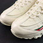 Undefeated x Air Max 95 Sail 2025 - Three-Quarter Lateral Top View of Both Shoes on Dark Background Showing Sail AM95 Upper Dark Green and Red UNDEFEATED Dual Stripe on Lateral Midfoot and Sail White Rope Laces