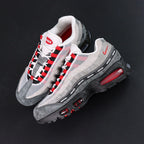 Undefeated x Air Max 95 Bright Crimson 2025 - Rear Heel View of Both Shoes with Pikachu Plush on Dark Background Showing Red NIKE AIR Two-Line Text on Grey Suede Heel Counter Red Mini Swoosh and Crimson Tinted AM95 Air Units in Black Midsole