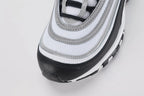 Air Max 97 Black Metallic Silver - Heel Counter Close Up on White Background Showing Black Air Max Text Woven Ribbon Pull Tab Metallic Silver Reflective Stripe Bands on Heel Panel and Transparent AM97 Air Unit Visible Through White Midsole
