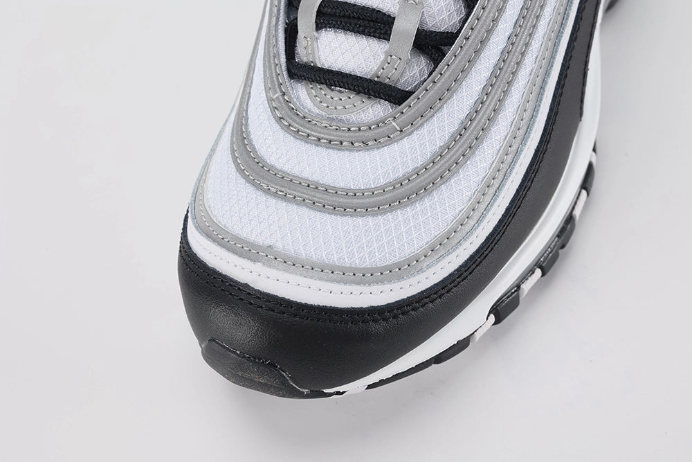 Air Max 97 Black Metallic Silver - Heel Counter Close Up on White Background Showing Black Air Max Text Woven Ribbon Pull Tab Metallic Silver Reflective Stripe Bands on Heel Panel and Transparent AM97 Air Unit Visible Through White Midsole