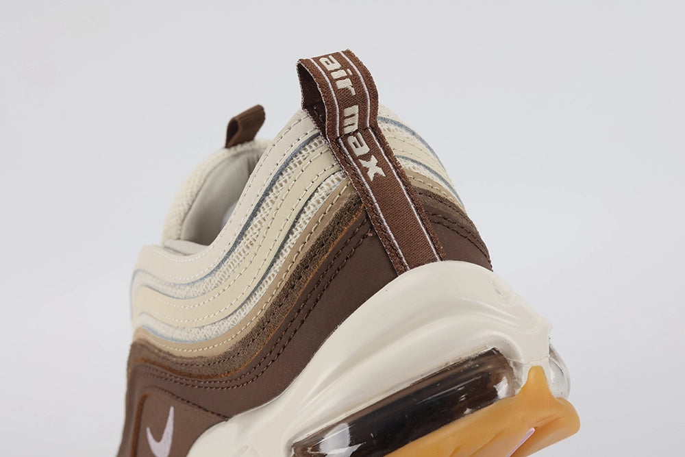 Air Max 97 Muslin Pink Foam - Heel Counter Close Up on White Background Showing Dark Brown Air Max Text Woven Ribbon Pull Tab Three-Tone Graduated Brown Wave Stripes on Heel Panel and Transparent AM97 Air Unit with Pink Foam Midsole Accent Line