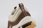 Air Max 97 Muslin Pink Foam - Heel Counter Close Up on White Background Showing Dark Brown Air Max Text Woven Ribbon Pull Tab Three-Tone Graduated Brown Wave Stripes on Heel Panel and Transparent AM97 Air Unit with Pink Foam Midsole Accent Line