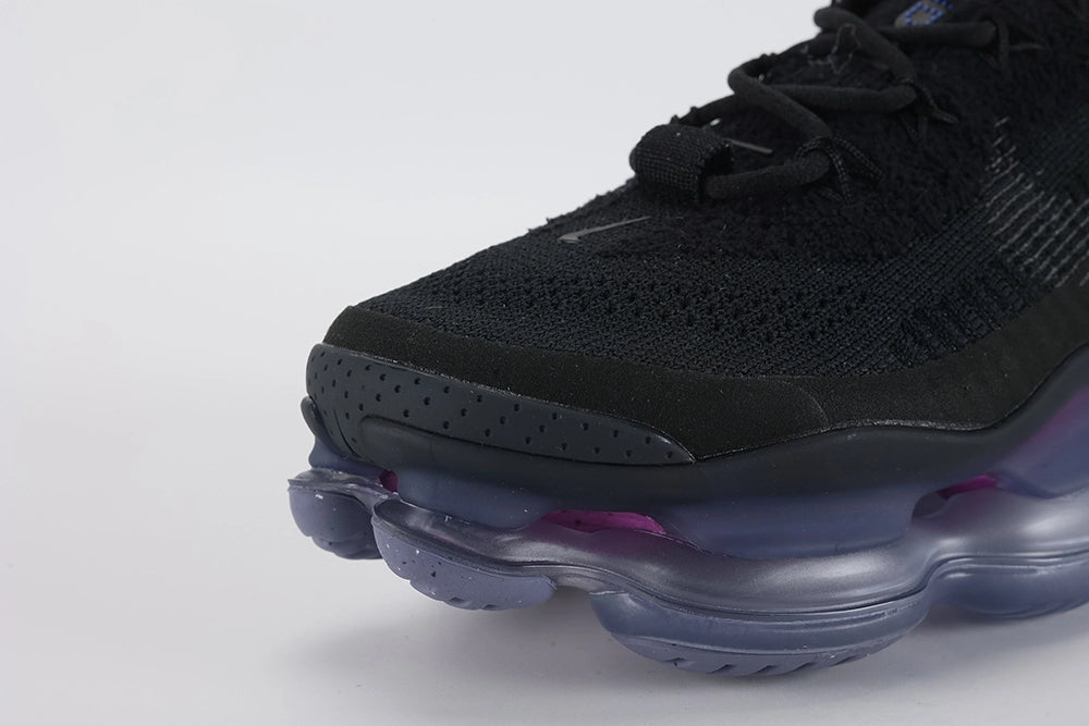 Air Max Scorpion Flyknit Black Persian Violet - Tongue and Lace Area Top Down View on White Background Showing Rectangular Royal Blue Dot-Grid Tongue Badge Black Tonal Mini Swoosh Embroidery Black Star-Form Lace Locks and Black Rope Laces on Black Loop-Pile Flyknit Upper