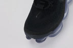Air Max Scorpion Flyknit Black Persian Violet - Rear View of Both Shoes on White Background Showing Black Wide Rubber Heel Pull Tabs with Royal Blue Dot-Grid Texture Black High Ankle Collar Persian Violet Mini Swoosh on Lateral Heel Midsole and Persian Violet to Slate Blue Gradient AM Scorpion Air Unit with Fuchsia Chambers