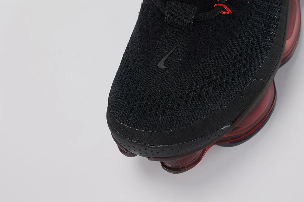 Air Max Scorpion Flyknit Bred Black University Red - Full Outsole View on White Background Showing Deep Burgundy Semi-Transparent AM Scorpion Air Base at Central Zone Black Rubber Chevron Traction at Outer Perimeter and Red Dot Detail at Toe-End Air Chamber Base