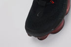 Air Max Scorpion Flyknit Bred Black University Red - Full Outsole View on White Background Showing Deep Burgundy Semi-Transparent AM Scorpion Air Base at Central Zone Black Rubber Chevron Traction at Outer Perimeter and Red Dot Detail at Toe-End Air Chamber Base